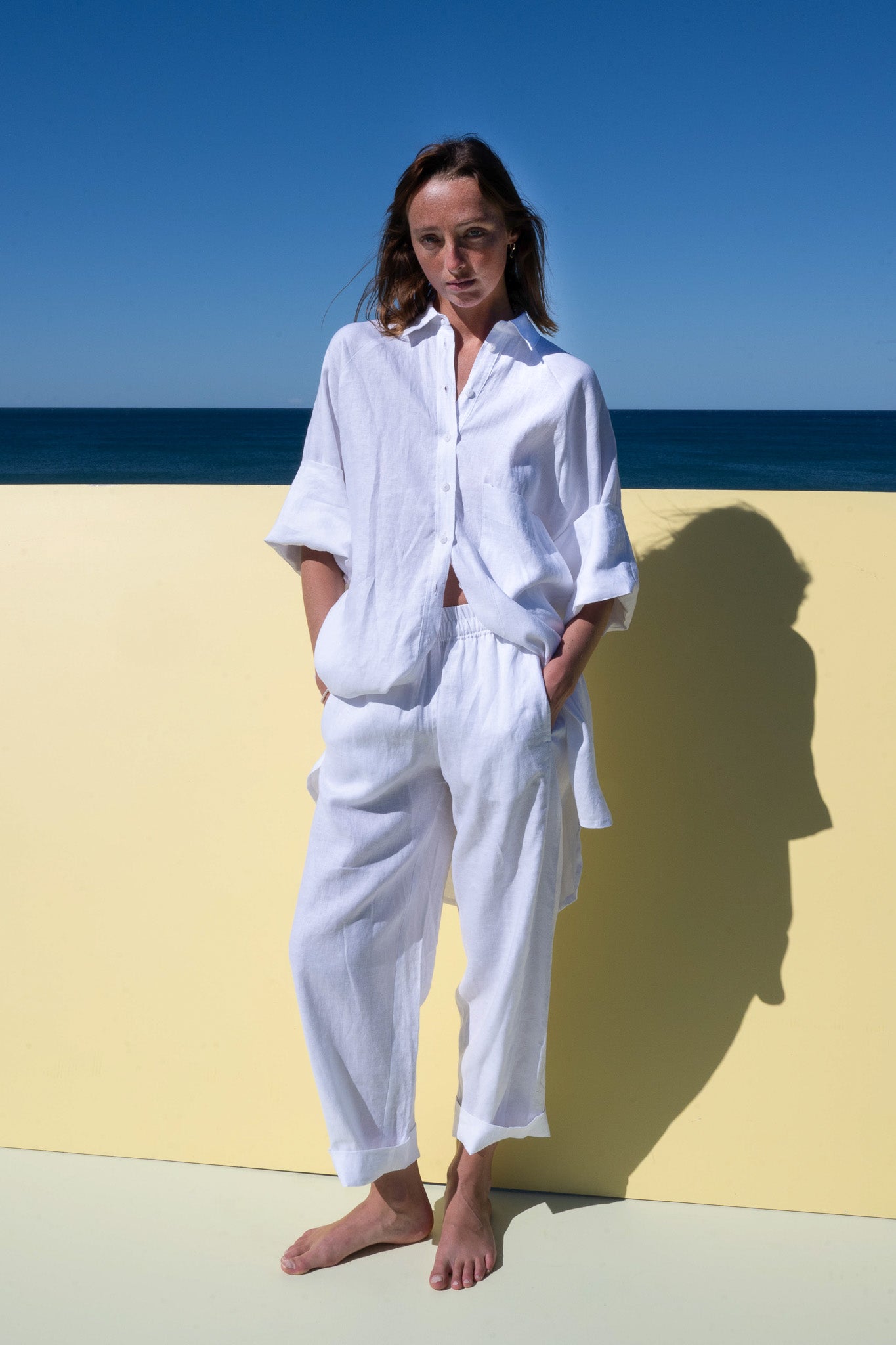 Oceanic Shirt Dress in white linen – button-down front view styled with relaxed fit pants