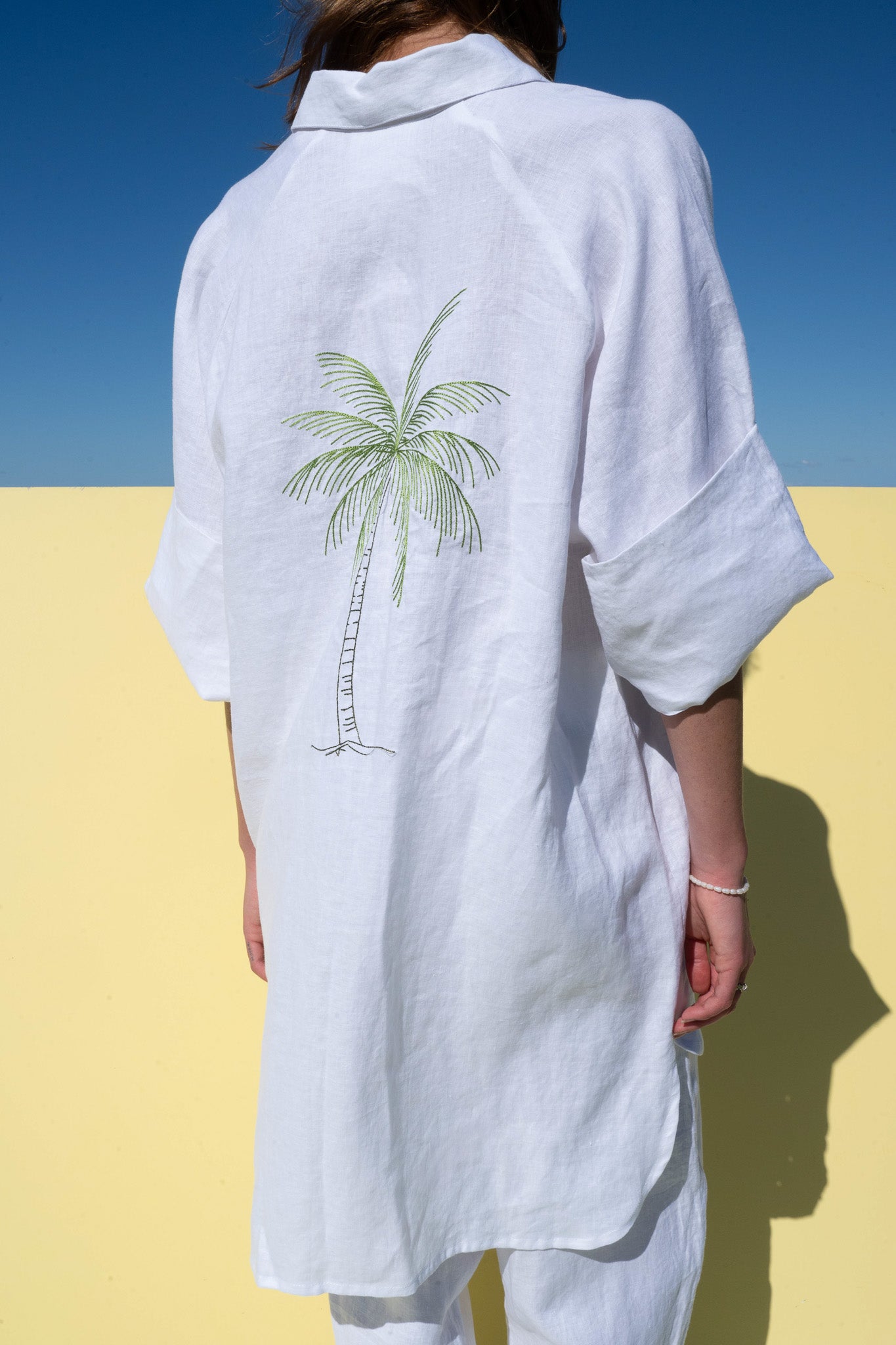 Oceanic Shirt Dress in white linen – close-up of embroidered palm tree design on the back