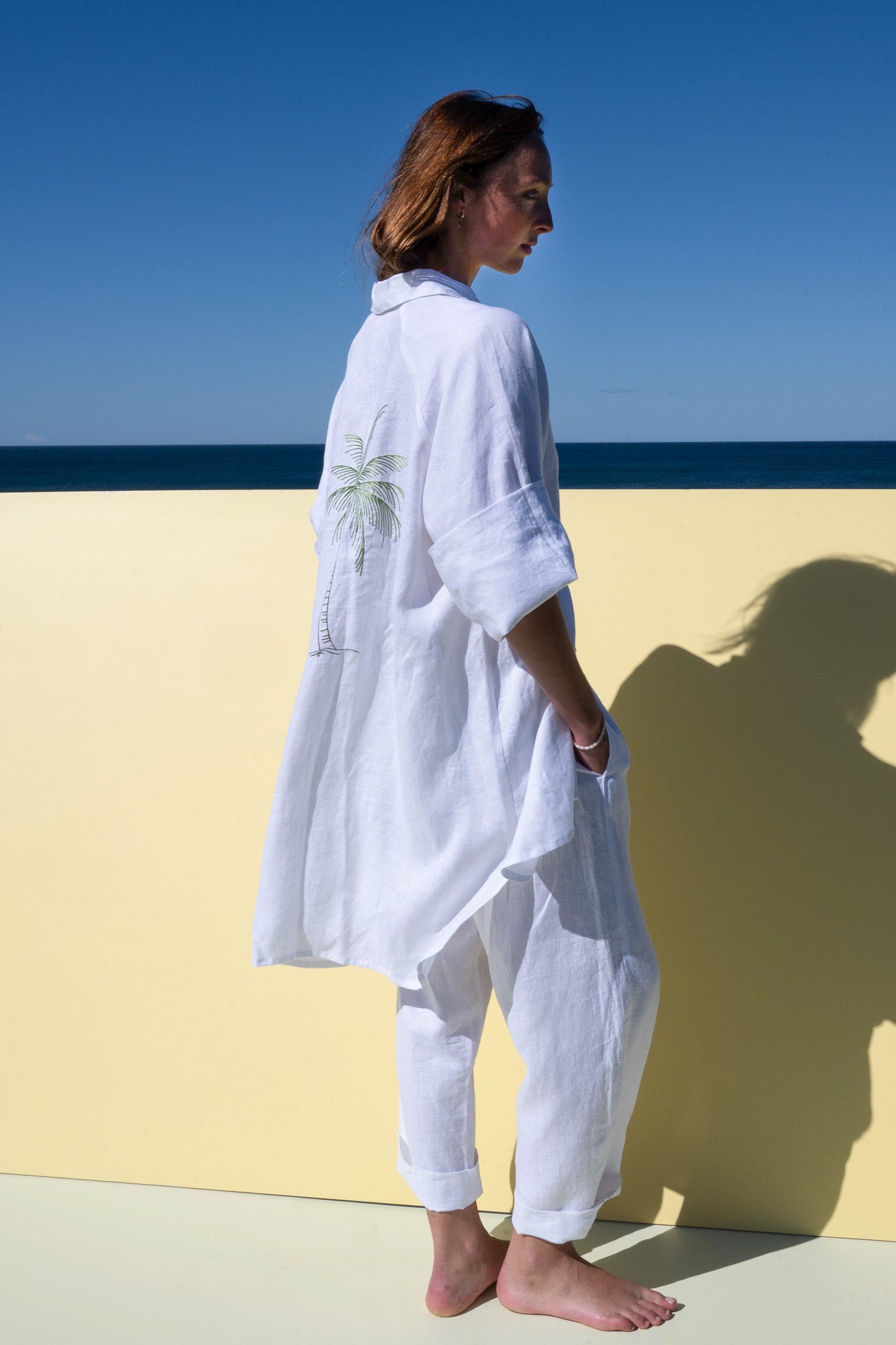 Oceanic Shirt Dress in white linen – side profile view showing palm embroidery and loose fit