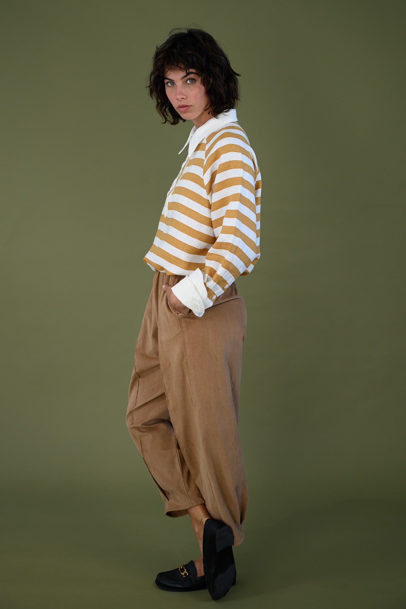 Salt pant in tawny brown cotton corduroy worn side view showing relaxed fit and tapered leg