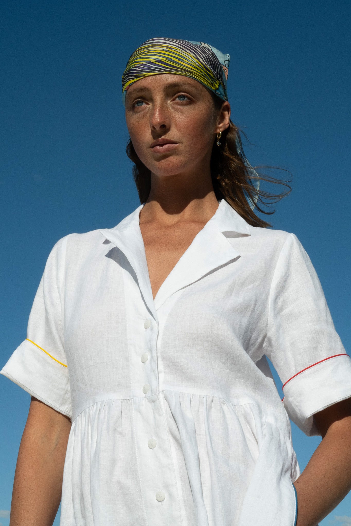 Detail shot of the Siena Dress in white linen showing sleeve piping and button front.
