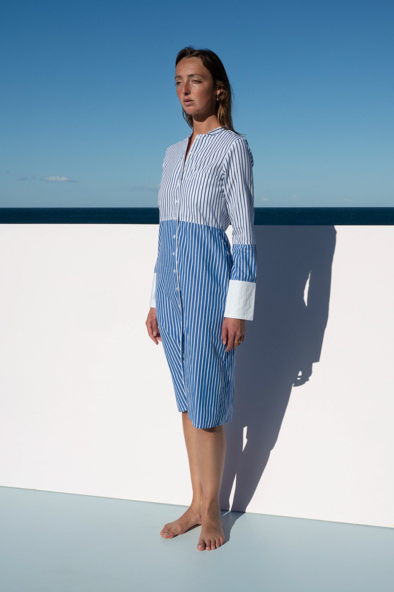 Side angle of the Sisto Dress in blue and white stripe with crisp white cuffs.