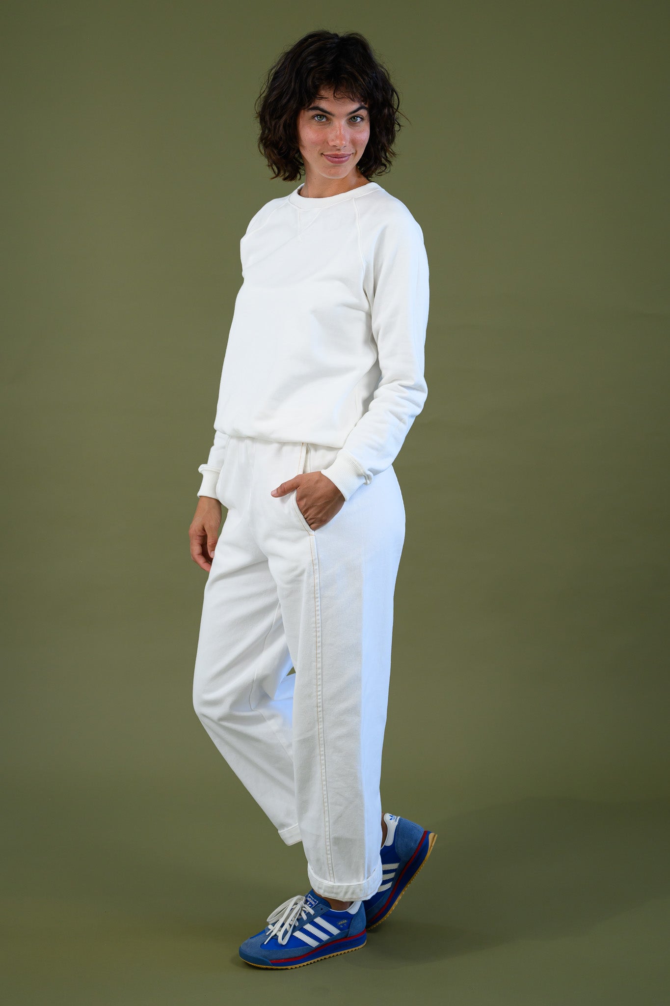 Blaze jogger in white organic cotton twill with a relaxed fit shown side view styled with matching white top and blue sneakers