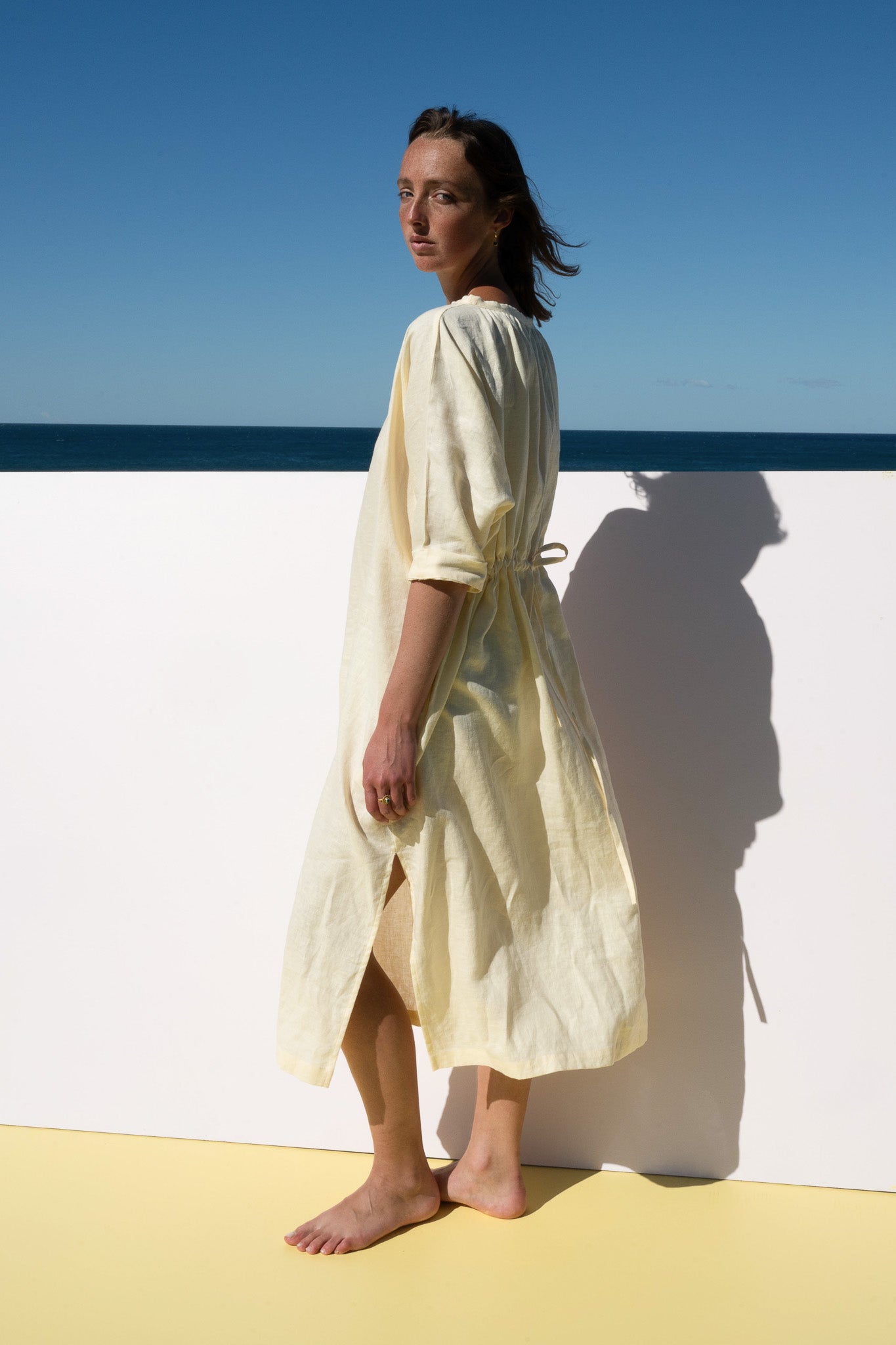 The Moments Dress in yellow linen – side profile highlighting midi length and airy linen fabric