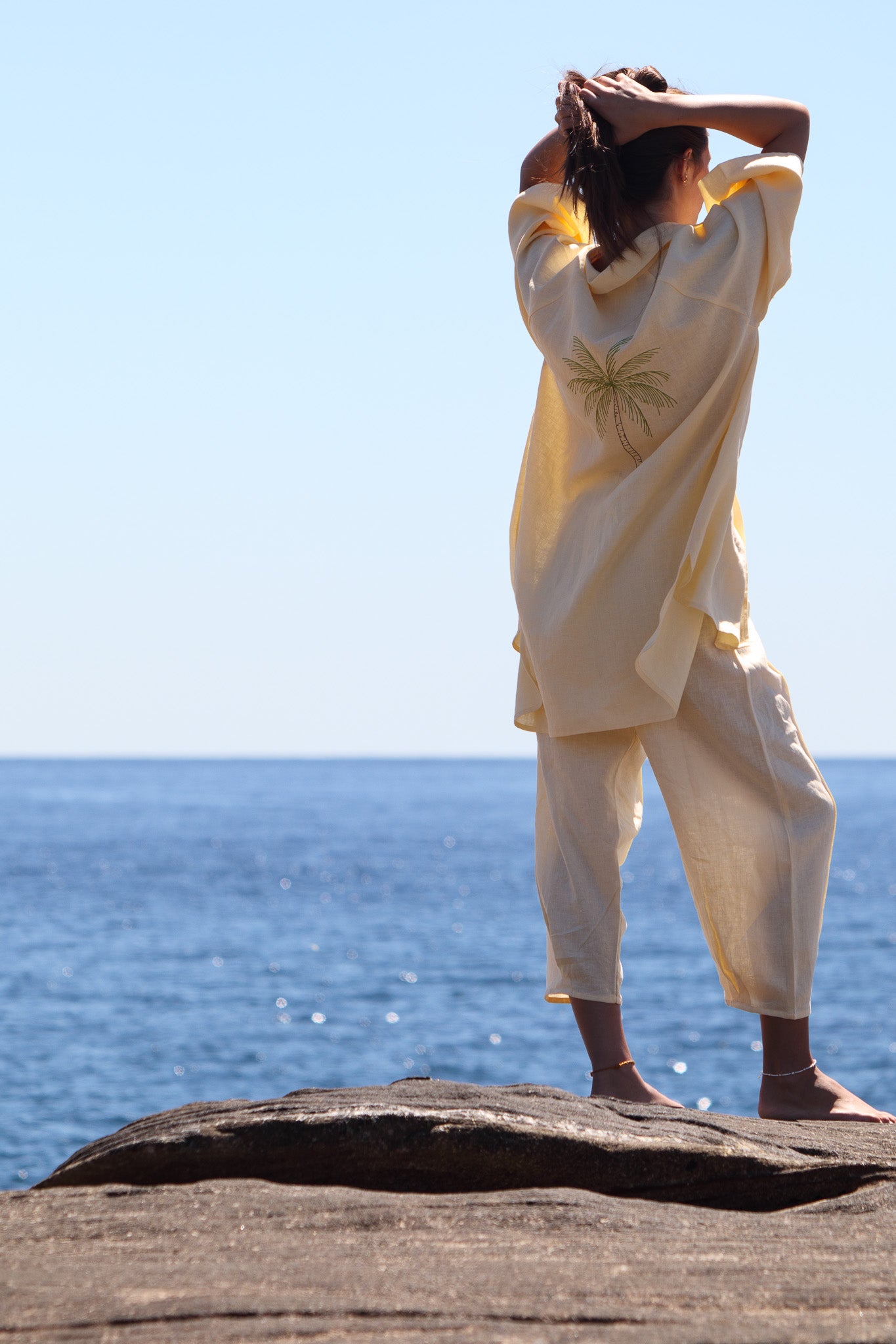 Back view of the butter yellow Oceanic Shirt Dress with palm tree embroidery and relaxed summer fit.