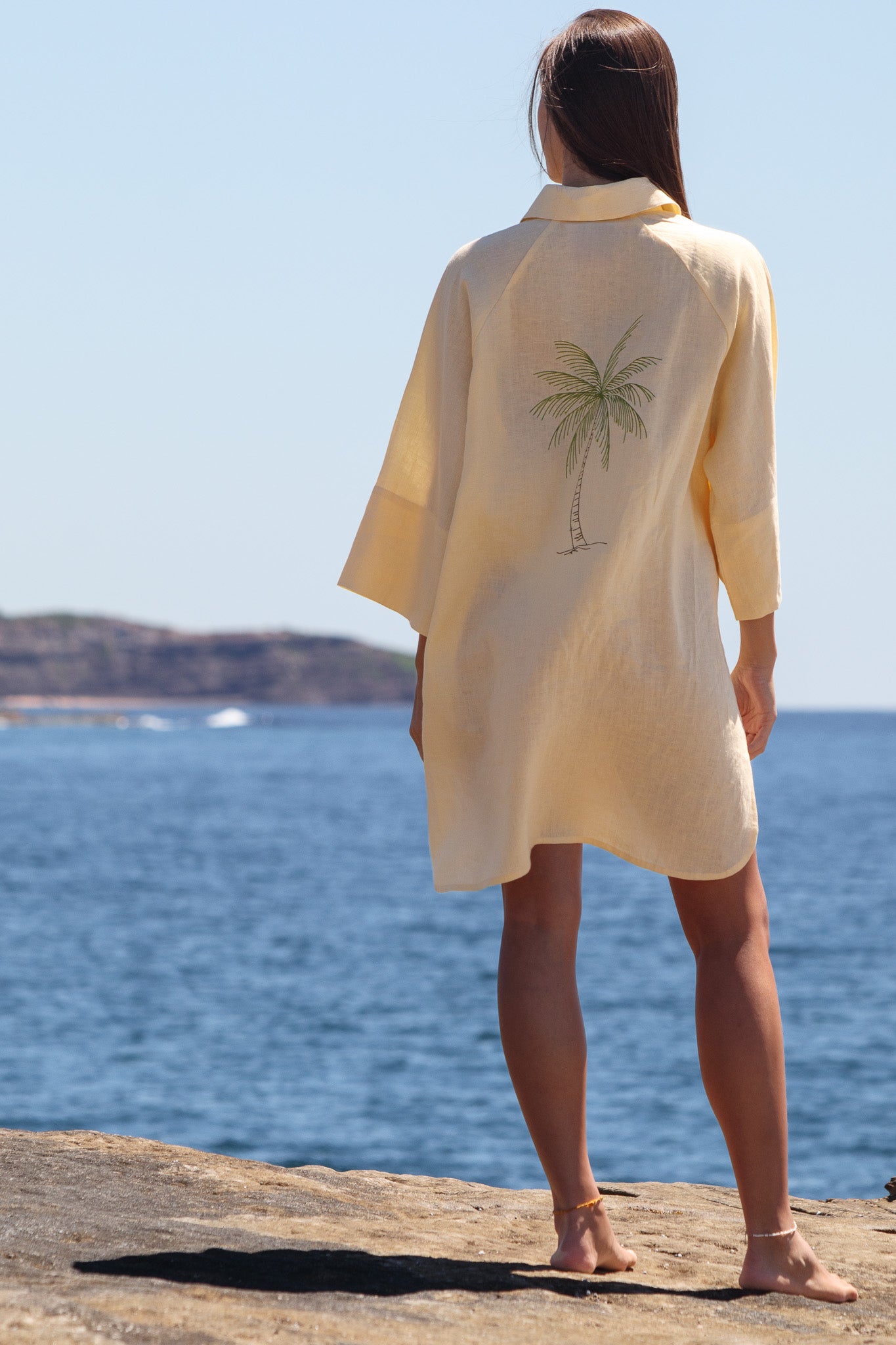 Palm tree embroidery detail on the back of the butter yellow Oceanic Shirt Dress.