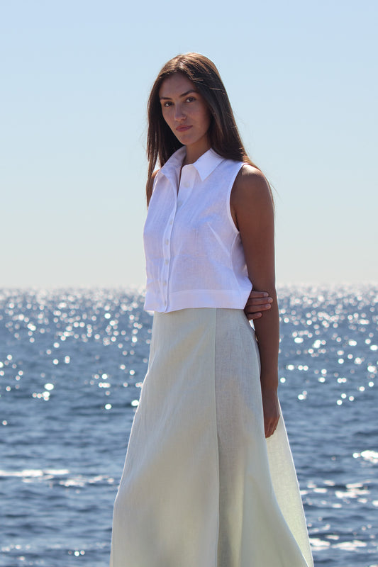 Front view of the Wrap Around Me Skirt in sun washed mint linen, showing the smooth A line fall against the ocean backdrop.