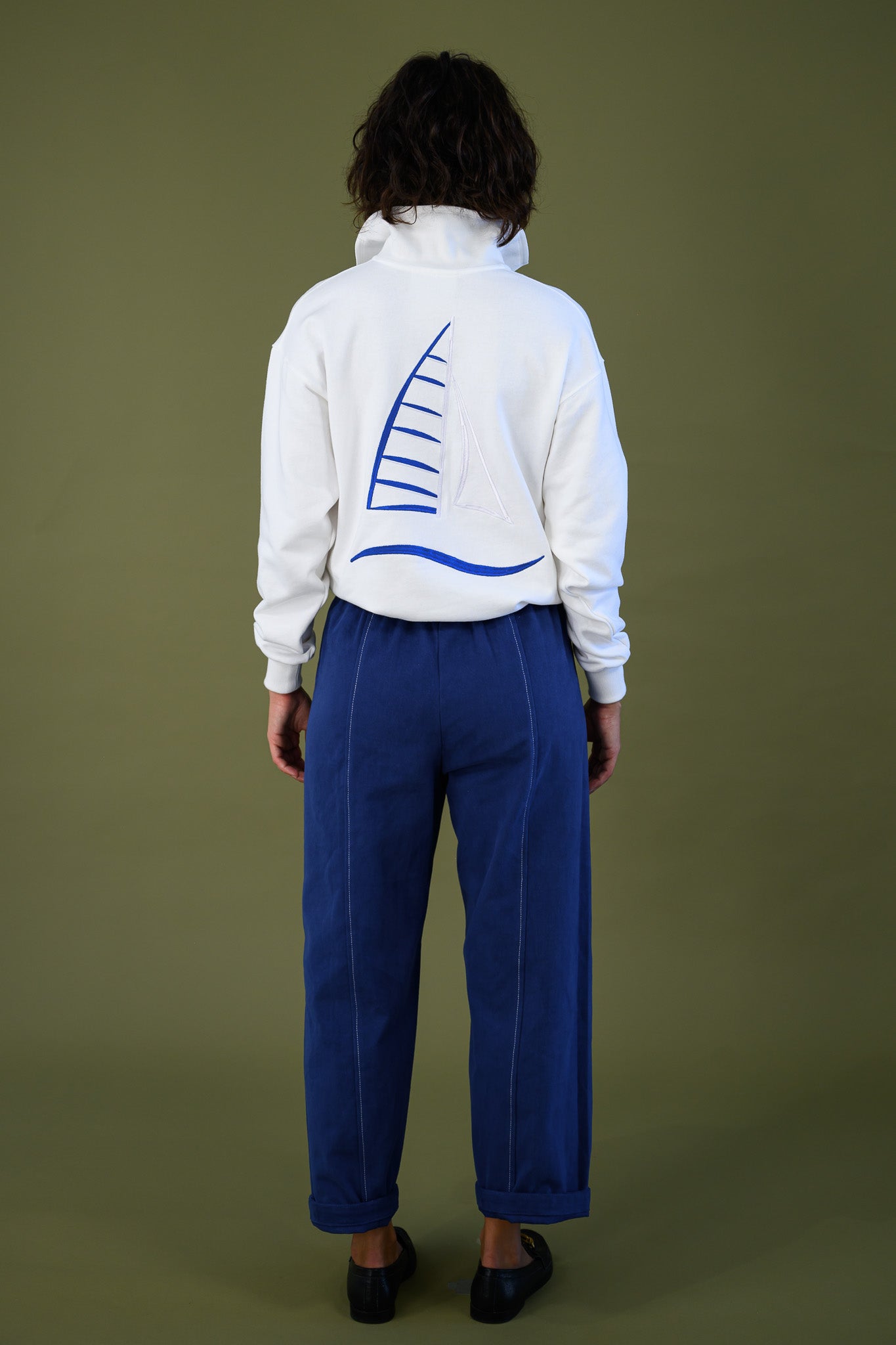 Full length back view of white cotton jumper with embroidered sailboat