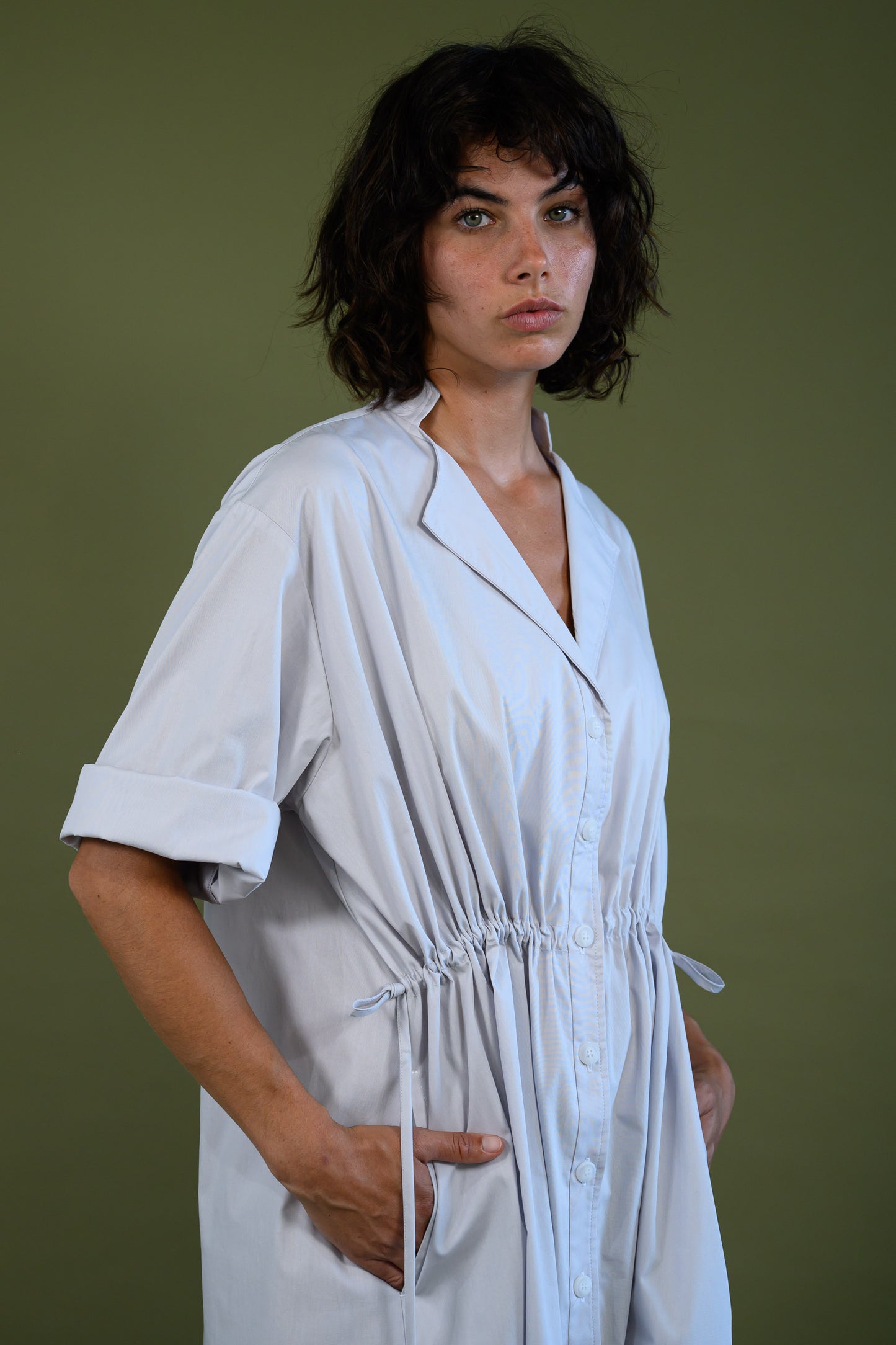 Angled front view of white cotton poplin dress highlighting relaxed fit