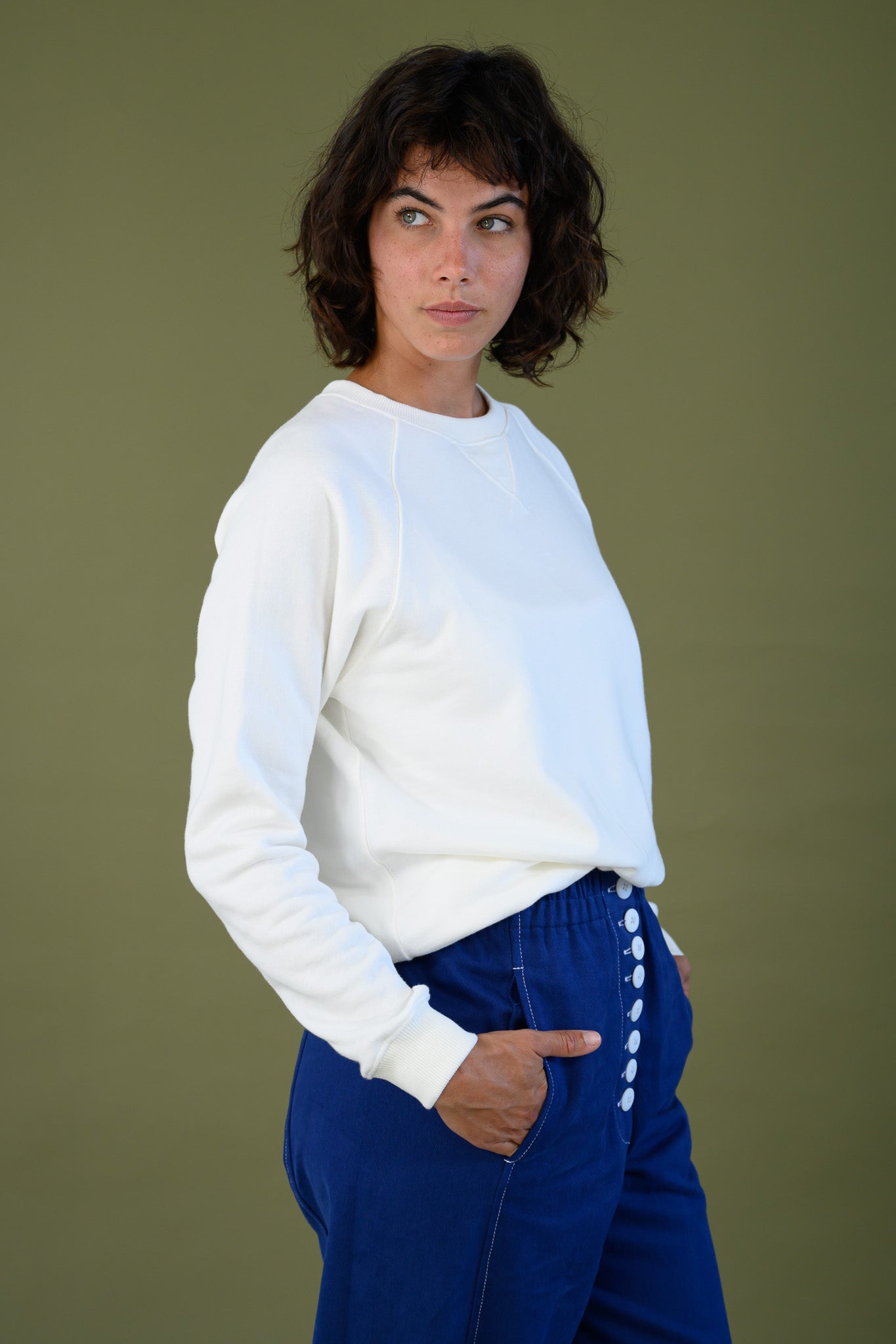 White cotton sweatshirt styled with blue pants showing relaxed everyday look