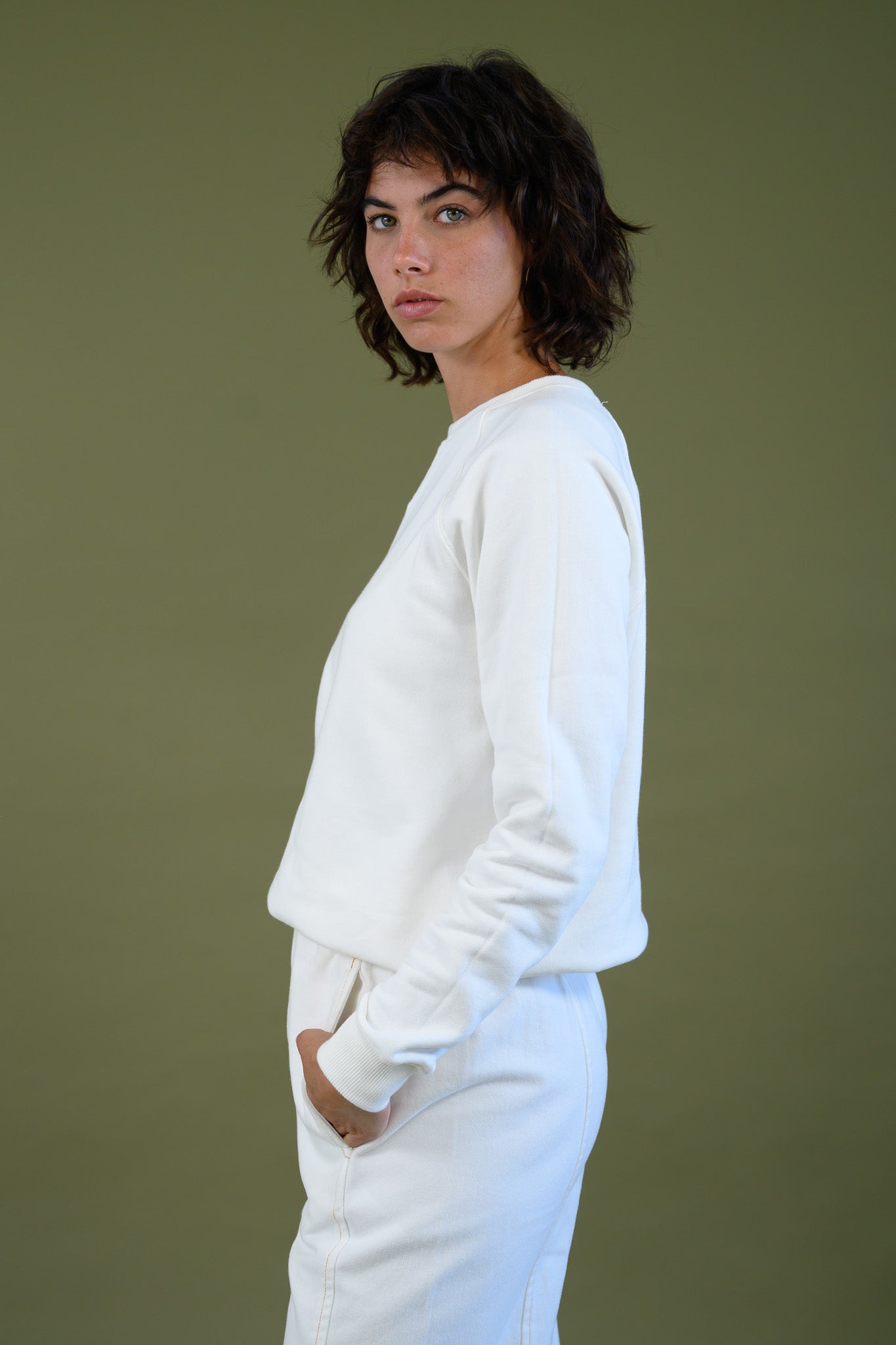 White cotton sweatshirt worn in relaxed pose showing fit from side
