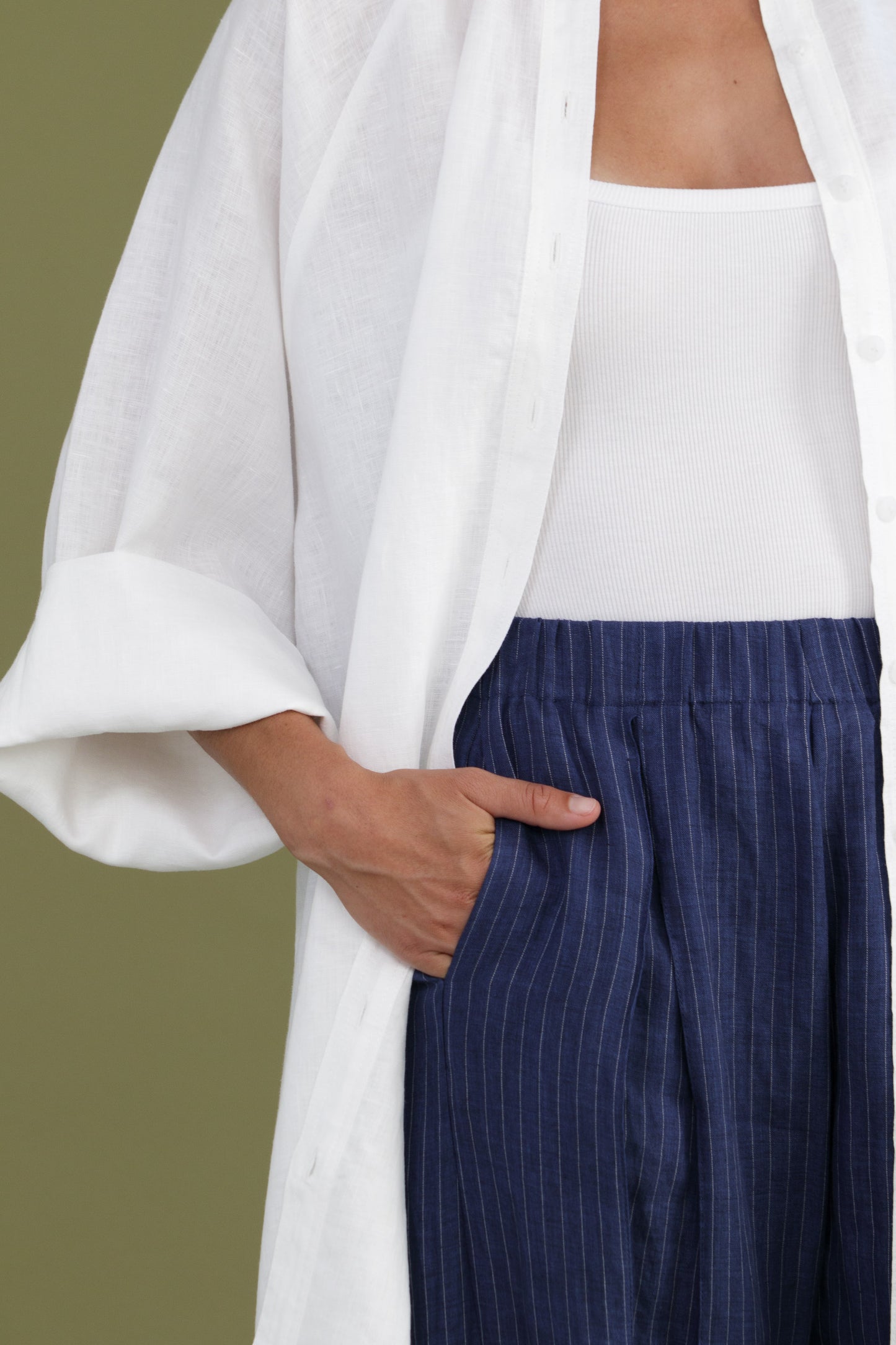 Front detail of white linen shirt dress showing oversized fit and chest pocket