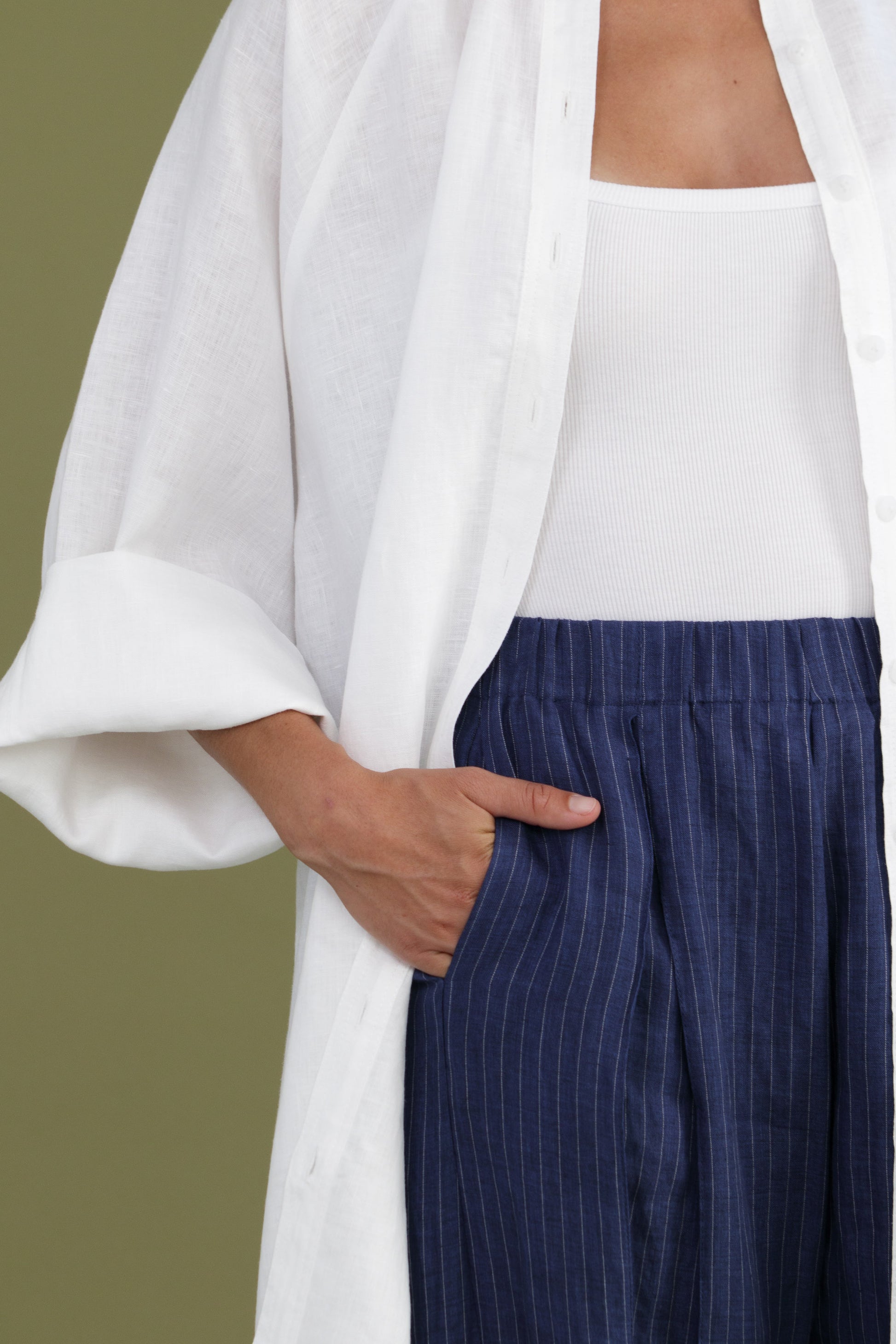 Front detail of white linen shirt dress showing oversized fit and chest pocket