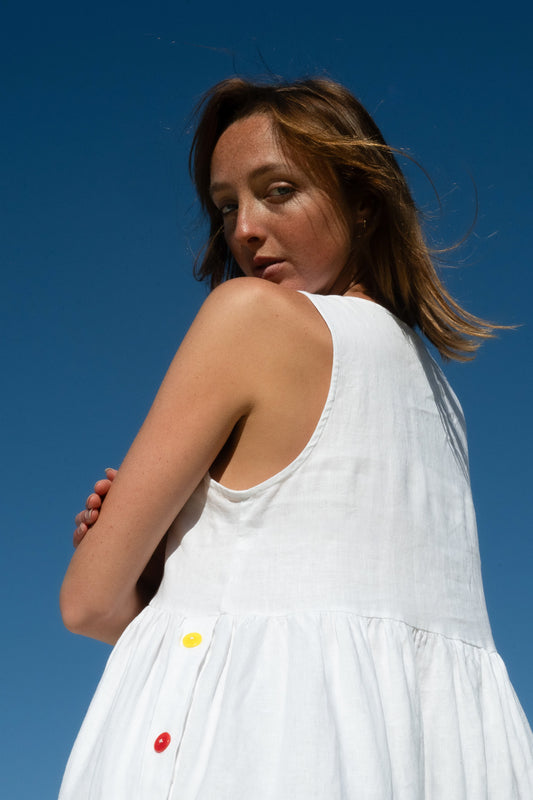 Close-up of Wonka Sleeveless Dress in linen, showing sleeveless cut and colourful button detail on the back.