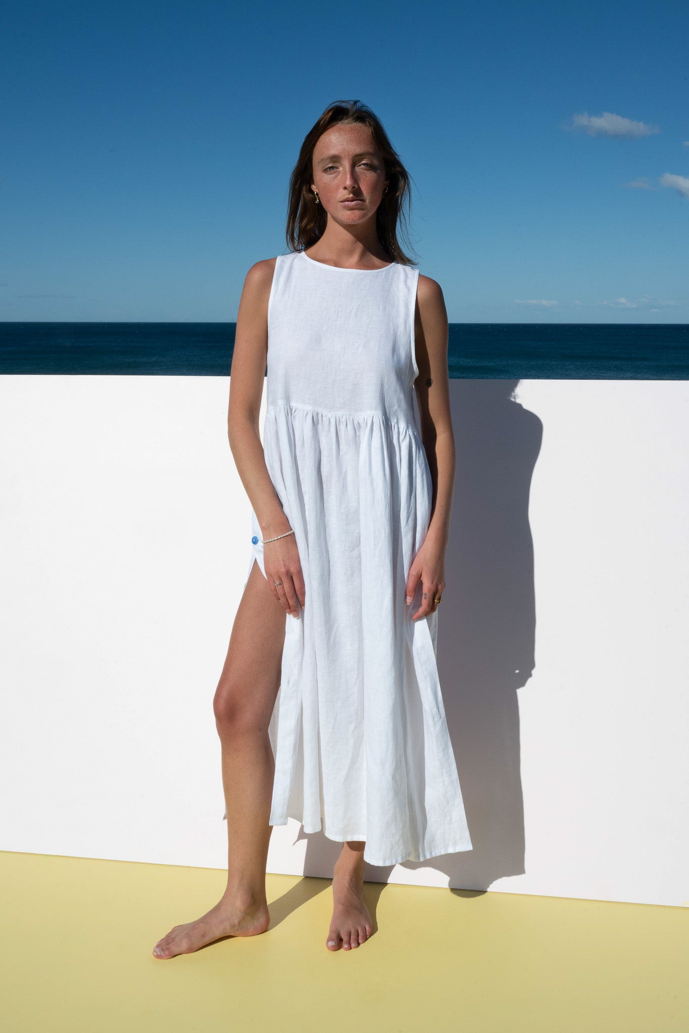 Front view of Wonka Sleeveless Dress in linen, relaxed silhouette with side button accents.