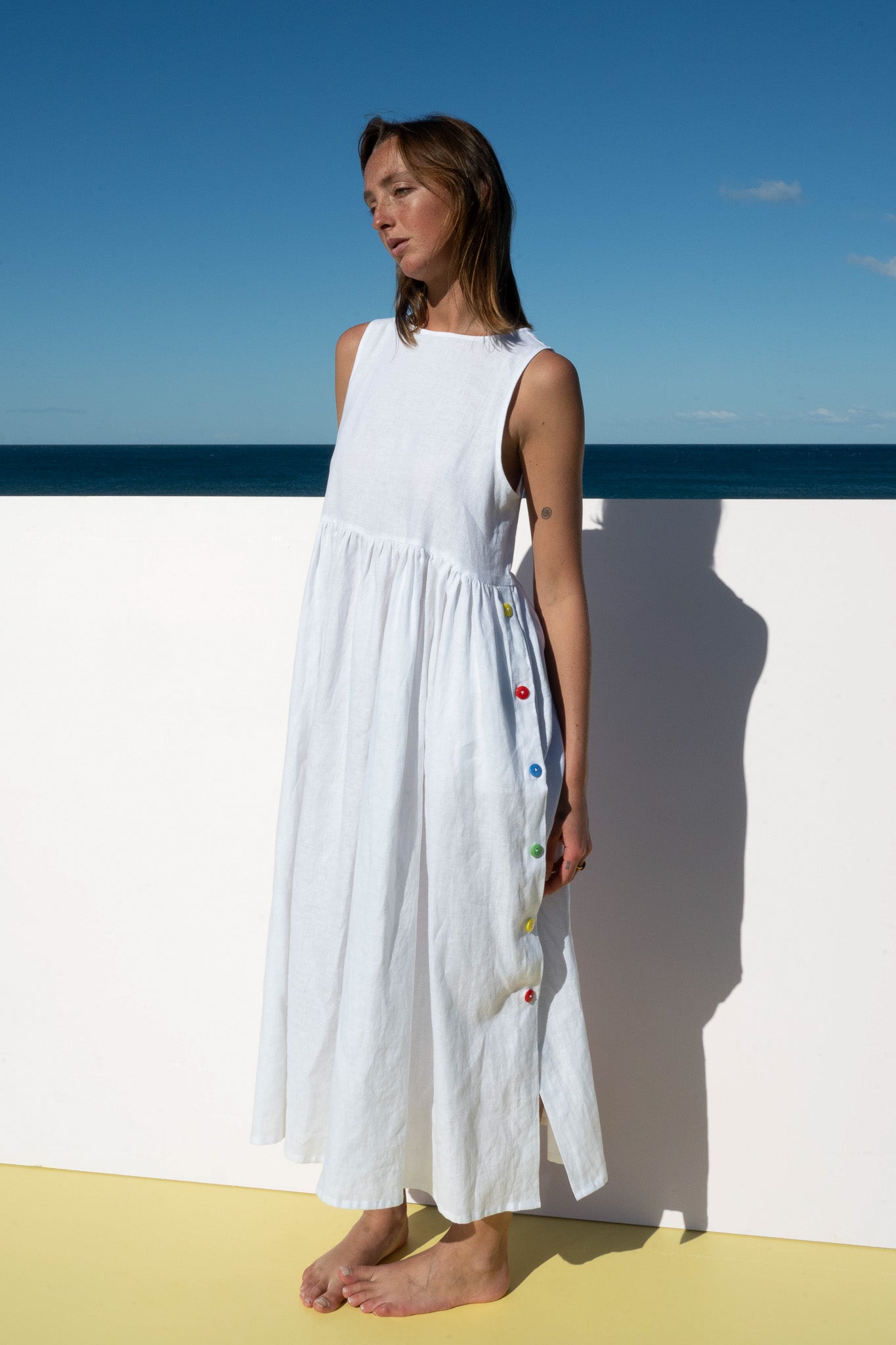 Side view of Wonka Sleeveless Dress in linen with playful rainbow button details.